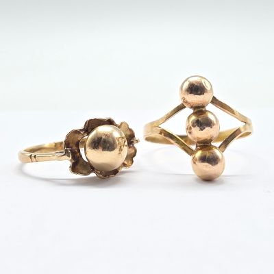 two gold rings, one with a ball and the other with a flower