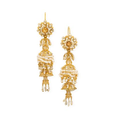 une paire de boucles d'oreilles dorées et blanches ornées de perles