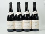 six bottles of wine are lined up on a white surface