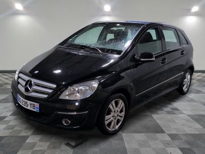 une photo d'une mercedes noire de classe b garée sur un sol en damier