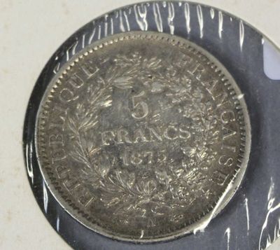 a silver coin sitting on top of a silver plate