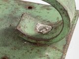 a close up of a green metal object on a white surface