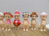 five figurines of children dressed in different outfits