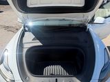 a white car with its trunk open in a parking lot