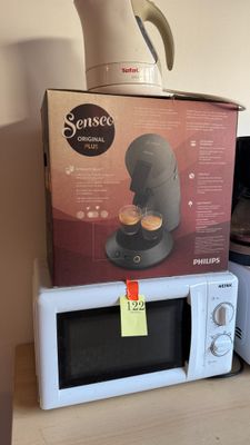 une boîte sur laquelle est posée une cafetière, posée elle-même sur un micro-ondes