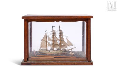 une petite maquette de bateau en bois exposée dans une vitrine