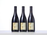 three bottles of wine are lined up on a table