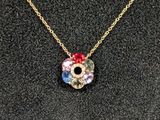 un collier en or orné d'une fleur rouge, blanche et bleue