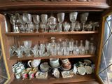 a wooden cabinet with a lot of glasses and plates on it