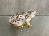 une figurine de grenouille posée sur une table en verre
