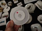 a person holding a plate in front of a table full of plates