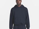 a man in a black hoodie and sweatpants stands in front of a white background