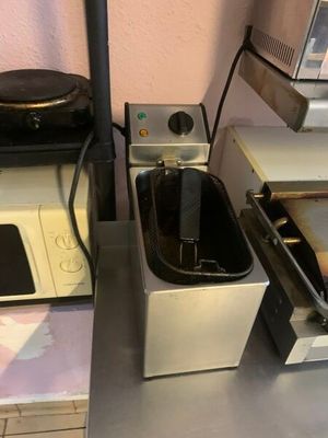une petite cuisine équipée d'une cuisinière, d'un micro-ondes et d'un grille-pain