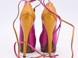 pair of pink and yellow high heeled shoes tied up to a string