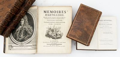two old books and a leather case on a white surface