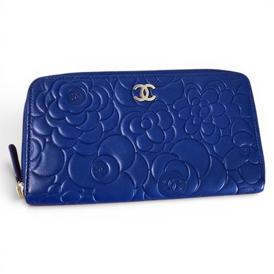 a close up of a blue purse on a white surface