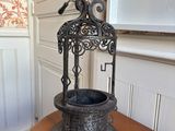 a metal birdcage on a wooden table in a room