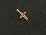 a gold cross with pink stones on a black background