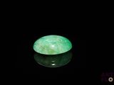 an image of a green jade stone sitting on top of a black surface