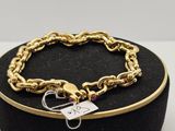 bracelet plaqué or avec une breloque en forme de cœur, présenté dans un coffret en velours noir