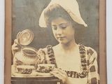 une vieille photo d'une femme tenant une assiette sur laquelle est posé un gâteau