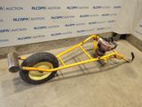 an image of a small yellow car with a big wheel
