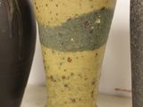 three vases sitting on a shelf next to each other