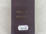 a close up of a book on a white surface with a tag on it