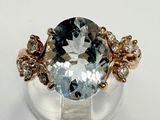 an image of a ring with a blue topaz stone surrounded by small white diamonds