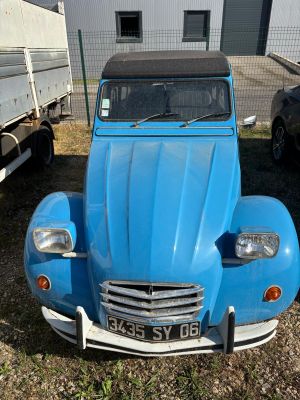 a small blue car parked in front of a building