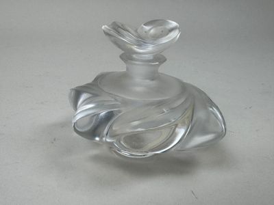 a clear glass bottle with a bird on top of it