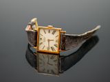 a close up of a wrist watch on a reflective surface