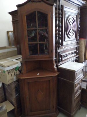 a wooden cabinet with a glass door in a room full of boxes