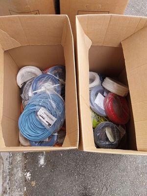 deux boîtes posées par terre, contenant chacune des cordons de couleurs différentes