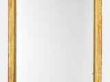 un miroir à cadre doré accroché à un mur sur fond blanc