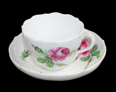 une tasse et une soucoupe blanches ornées de fleurs roses