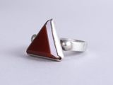a close up of a silver ring with a red stone in it