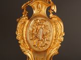 a gold vase with a picture of a woman on it