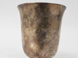 un vase en argent posé sur une surface blanche