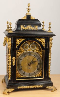 a black and gold clock sitting on a wooden table