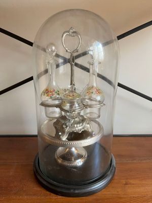 a glass dome with a clock inside of it on a table