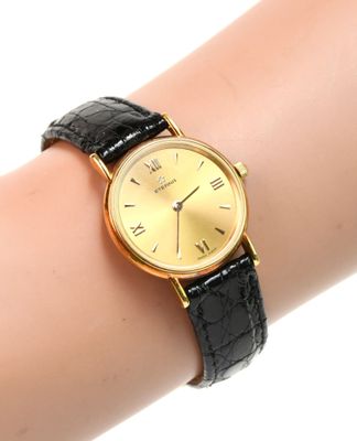 une photo du poignet d'une femme portant une montre en or