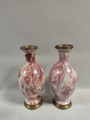 pair of pink and gold vases sitting on a white surface