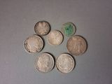 six types de pièces différents sont disposés en cercle sur une surface grise