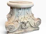 an image of a white marble pedestal with carvings on it