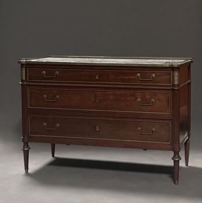 une commode ancienne avec un plateau en marbre dans une pièce