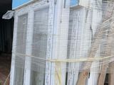 a pile of windows sitting on a pallet in front of a building