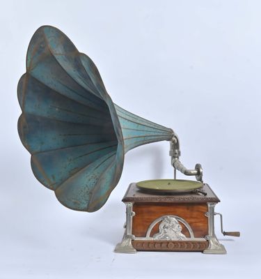 un vieux gramophone dans un coffret en bois posé sur une surface blanche
