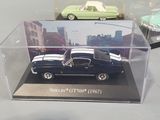 two toy cars in a display case on a table