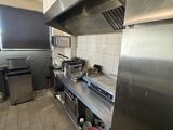 a large stainless steel kitchen with a stove and a refrigerator